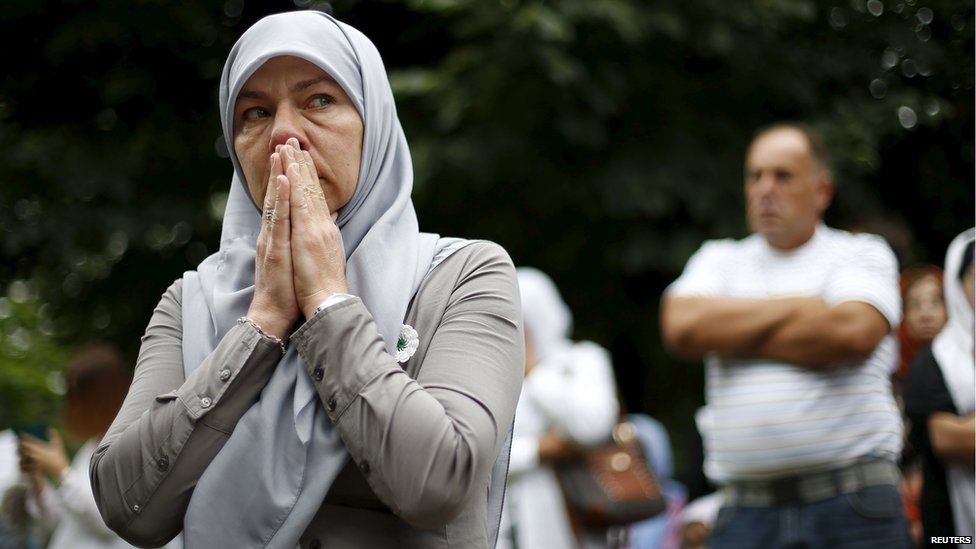 A woman reacts as she stands near a truck carrying 136 coffins of newly identified victims of the 1995 Srebrenica massacre, in the village of Visoko,Bosnia and Herzegovina, July 9, 2015.