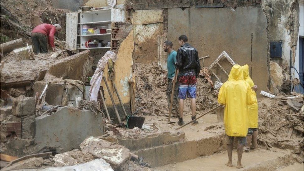 Мужчины работают на обломках дома, который рухнул во время оползня, вызванного проливными дождями, в Жардим-Монте-Верде, в районе Ибура, Ресифи, Бразилия, 28 мая 2022 г.