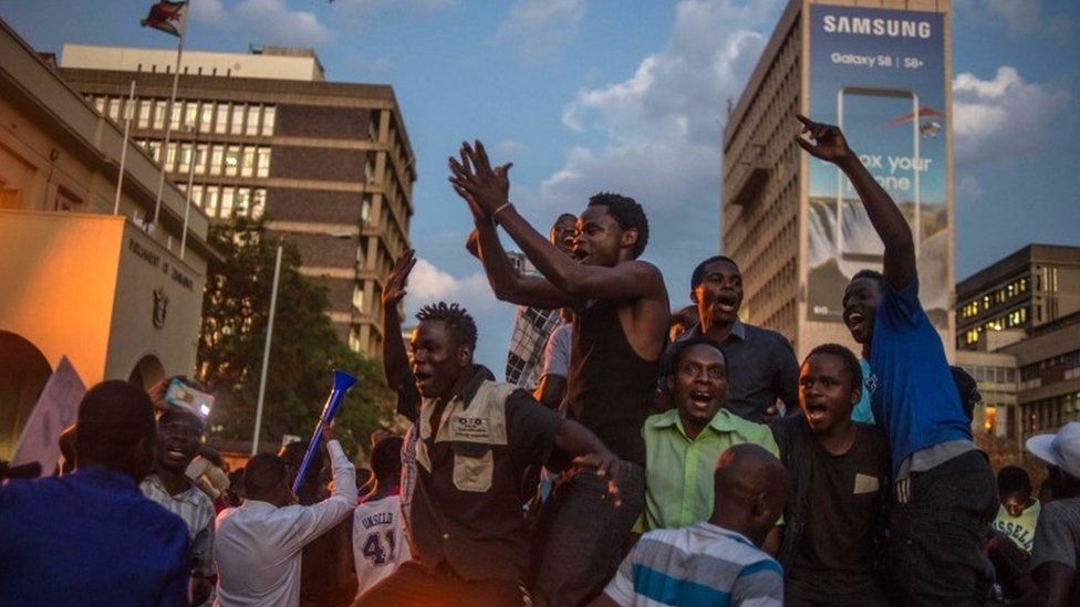 Harare residents celebrate in front of the parliament after the resignation of Zimbabwe's President Robert Mugabe (21 November 2017)