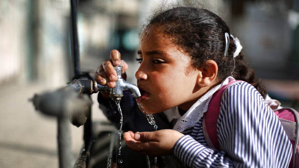 Girl drinking from outside tap