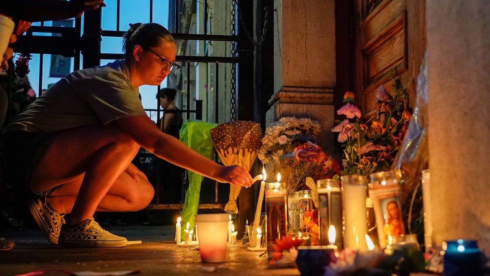 A woman lighting a candle at the vigil for victims of the Dayton, Ohio, shooting