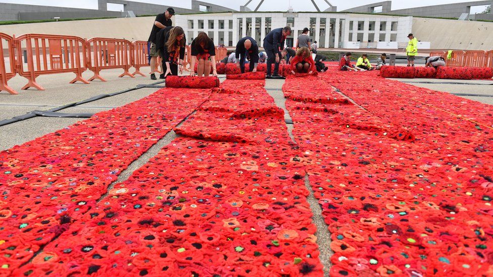 European Union ambassadors help with the installation of 270,000 poppies, ahead of Remembrance Day commemorations, outside Parliament House in Canberra, Australian Capital Territory, Australia on Wednesday