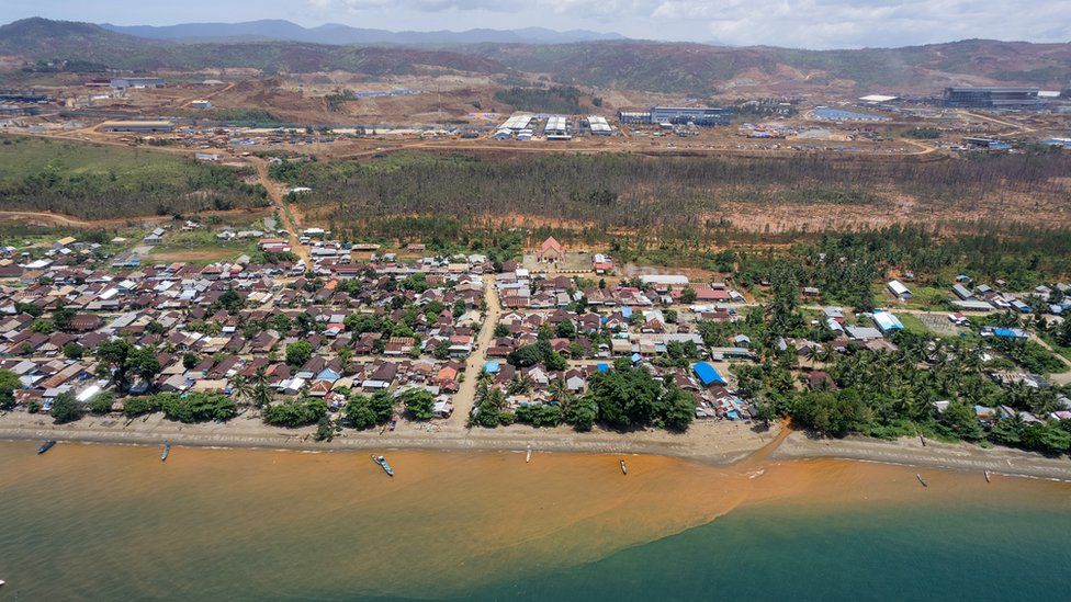 Red sediment pours from a river into the sea in the village of Kawasi in October 2022