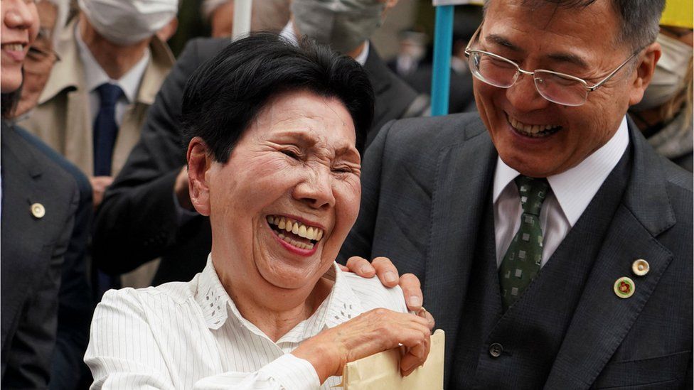 Hideko Hakamada (C) and Hideyo Ogawa (R), a lawyer for her brother Iwao Hakamada, share a smile in front of the Tokyo High Court on March 13, 2023