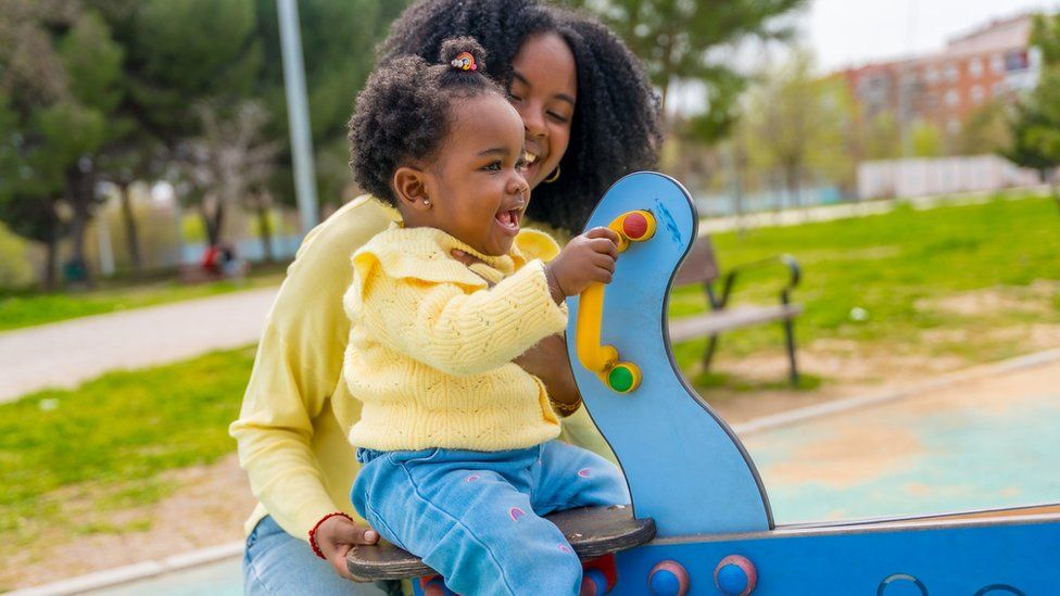 Stock image of a mother playing with a child in the park