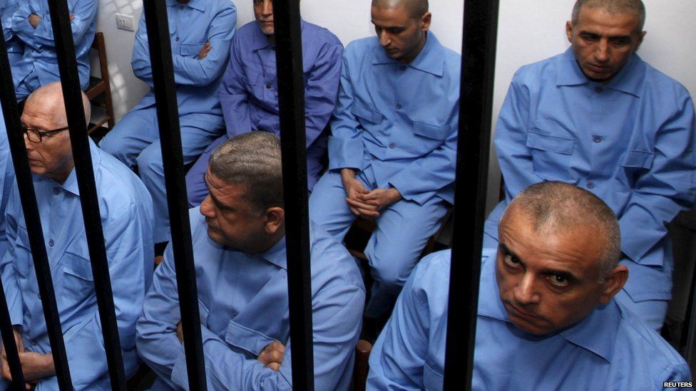 Former Gaddafi regime's officials sit behind bars during a verdict hearing at a courtroom in Tripoli, Libya - 28 July 2015