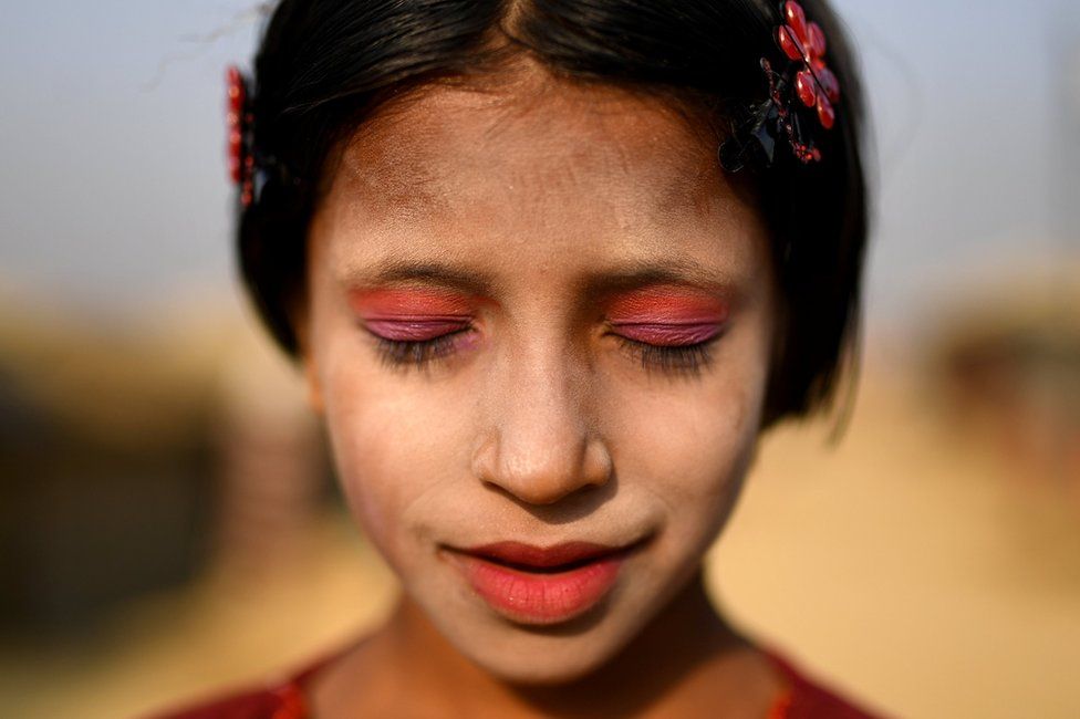 Rohingya refugee Amina poses for a photograph as she wears thanaka paste at Kutupalong camp in Cox's Bazaar, Bangladesh