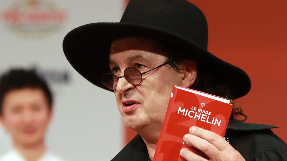 French chef Marc Veyrat, holds a Michelin guide after being awarded the maximum three Michelin stars at La Seine Musicale in Boulogne-Billancourt near Paris, 5 February 2018