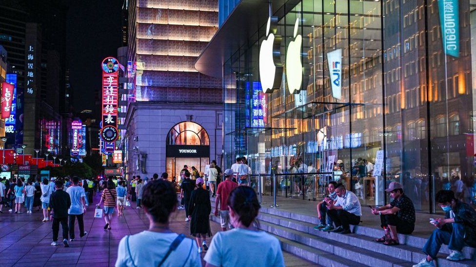A Shanghai night-time scene outside an Apple store in the company's trademark glass-and-steel style