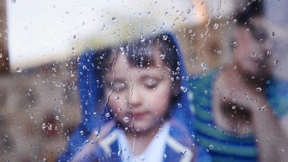 Child at wet window