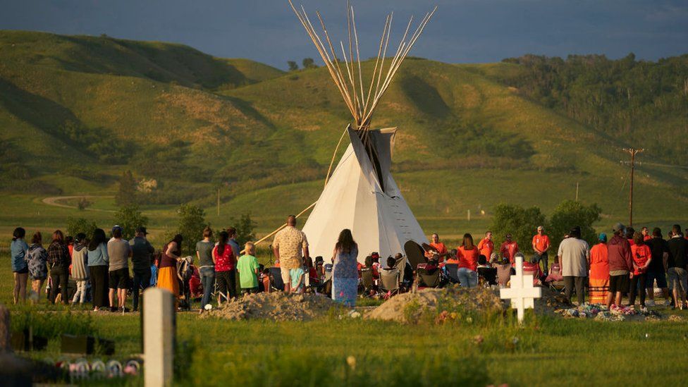 Hundreds of people gather for a vigil in a field where human remains were discovered in unmarked graves at the site of the former Marieval Indian Residential School on the Cowessess First Nation in Saskatchewan on June 26, 2021