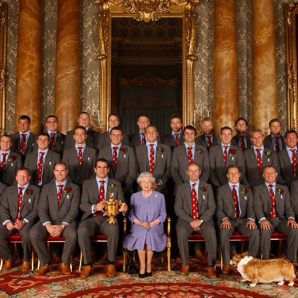 Queen Elizabeth II, and Berry the corgi, with the England rugby squad, at a reception at Buckingham Palace in London to celebrate winning the Rugby World Cup.