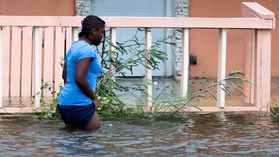 A woman walks in a flooded street after the effects of Hurricane Dorian arrived in Nassau, Bahamas, September 2, 2019