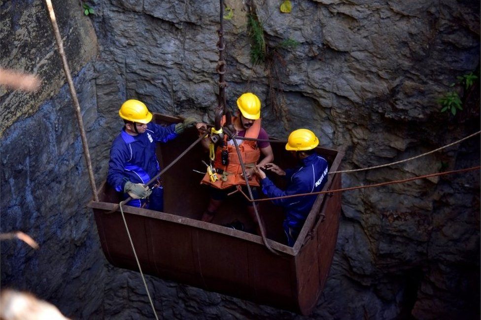 Divers use a pulley to enter a coal mine that collapsed in Ksan, in the northeastern state of Meghalaya, India, December 29, 2018.