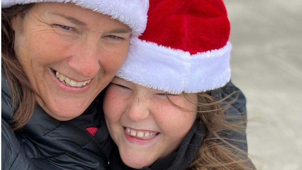 Annick and Émeline Ruedi don Santa hats to fight the chill on Texas' Mustang Island beach.