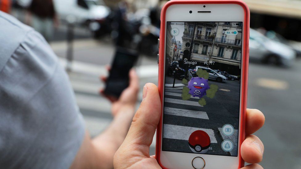 This picture taken on July 26, 2016 near the Louvre museum's pyramide in Paris shows the "Pokemon Go" app on the screen of a smartphone