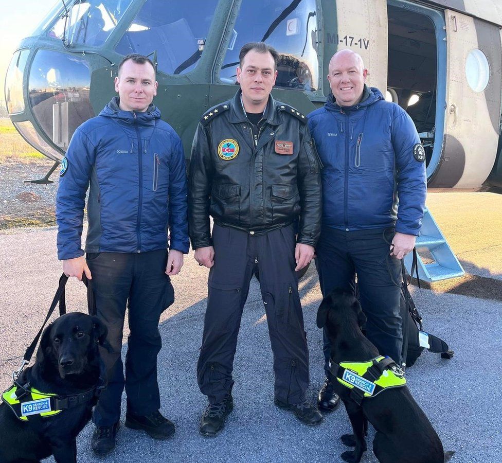 Ryan Gray (left), Kyle Murray (right) and their dogs Max and Delta with a helicopter pilot in Turkey