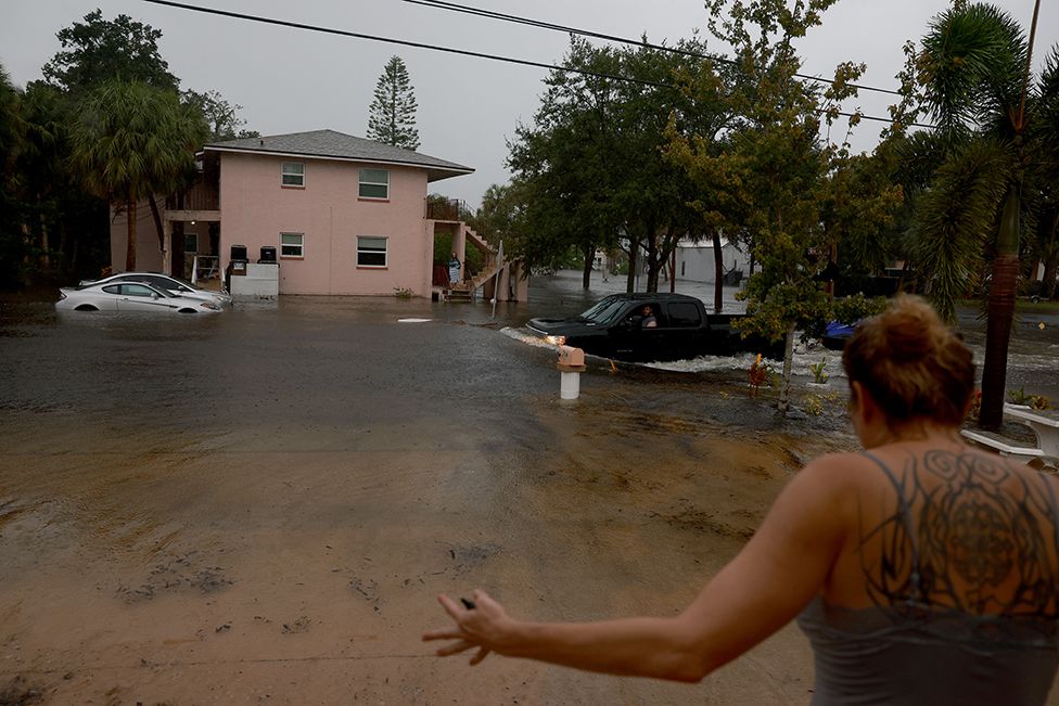 Грузовик проезжает по затопленным улицам, вызванным ураганом Идалия, проходящим мимо берега 30 августа 2023 года в Тарпон-Спрингс, Флорида