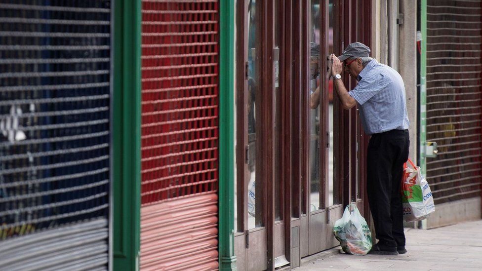 A man looks into a closed coffee shop