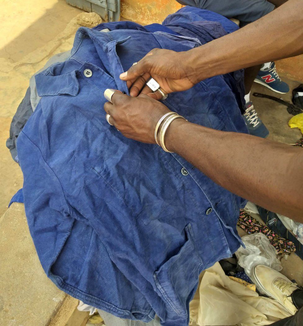 Amah Ayivi selects a blue worker jacket.