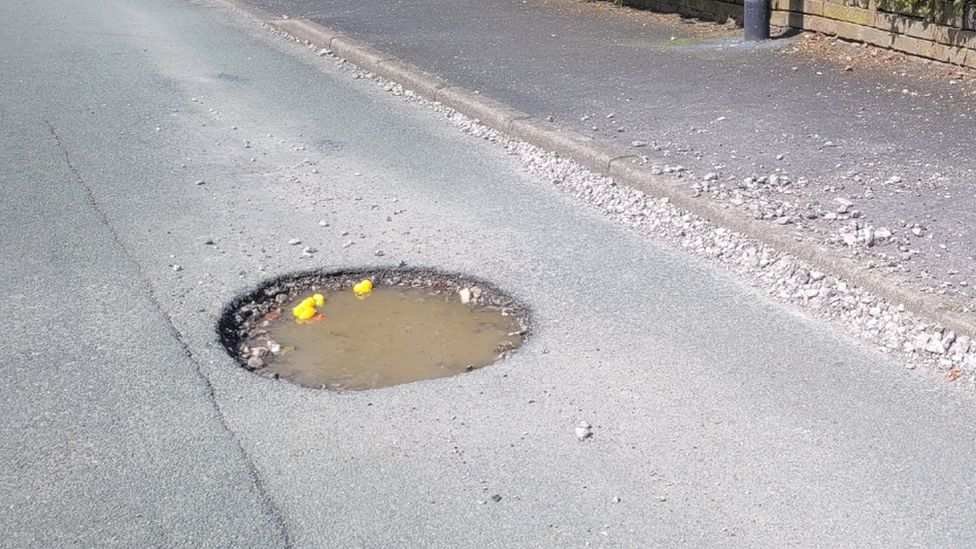 The flooded hole with rubber ducks floating on it