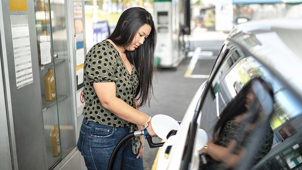 Woman using diesel pump at station