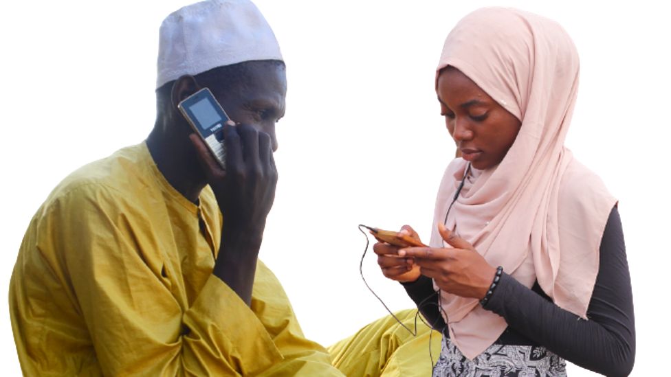 Мужчина и женщина из Нигерии пользуются мобильными телефонами