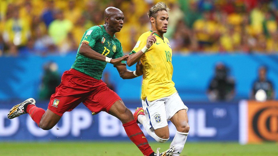 Stephane Mbia of Cameroon challenges Neymar of Brazil at the 2014 World Cup in Brazil