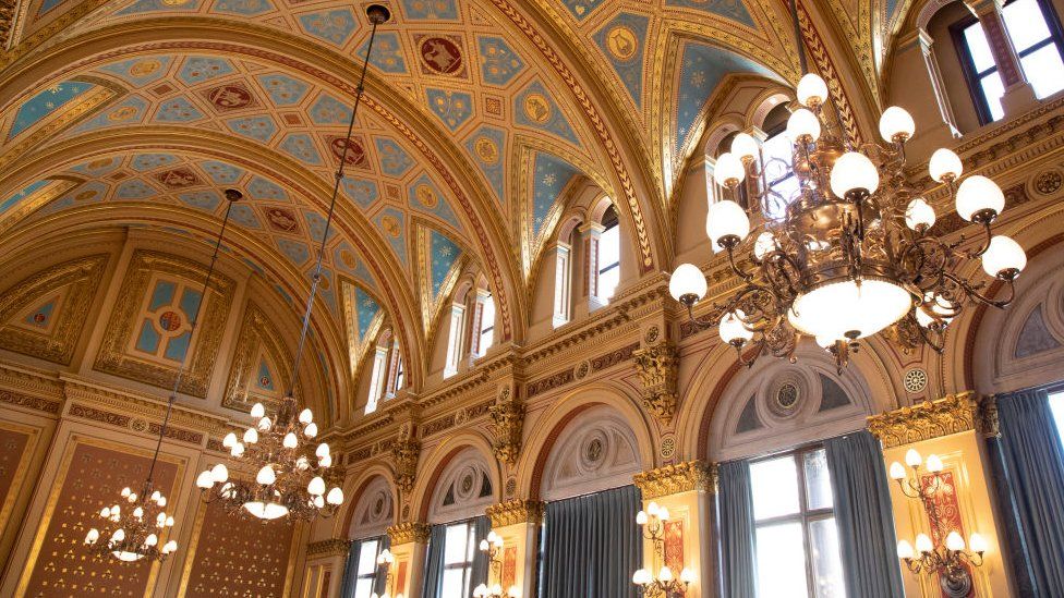 The ornate curved gold ceiling of the FCDO's Lorcarno Suite, with chandeliers hanging from the roof
