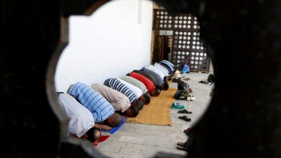 Men praying at a mosque in Tunis