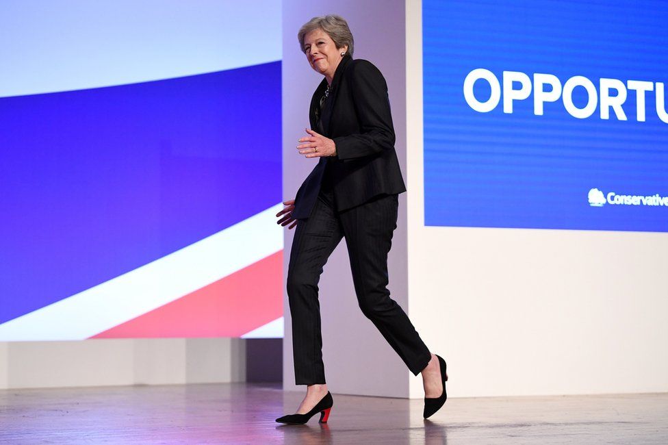 British Prime Minister Theresa May dances as she walks out onto the stage