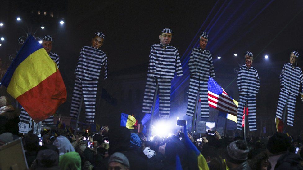 Romanian protesters hold up effigies of government officials