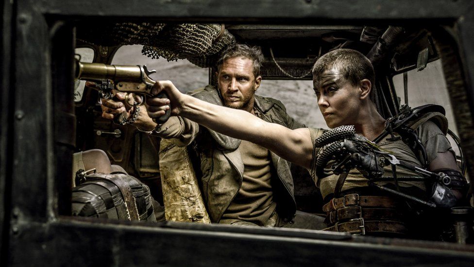Tom Hardy, center, as Max Rockatansky and Charlize Theron, right, as Imperator Furiosa