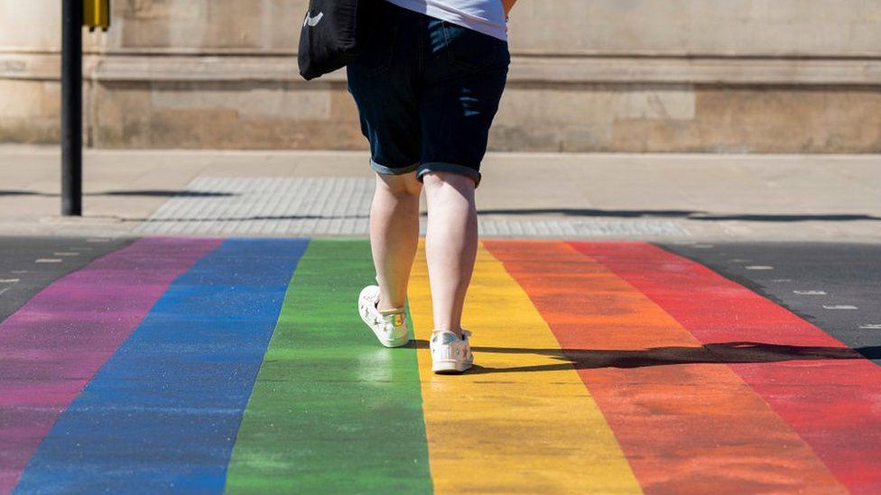 Woman walking over the rainbow crossing in Battersea