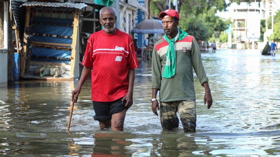 Two days earlier, these men walk through a flooded street in Beledweyne. Men walks through floodwater in Beledweyne, central Somalia, on May 12, 2023. The Shabelle River has burst its banks in Beledweyne, in central Somalia, forcing thousands of people to abandon their homes, according to the United Nations Office for the Coordination of Humanitarian Affairs (OCHA), and submerging markets and hospitals