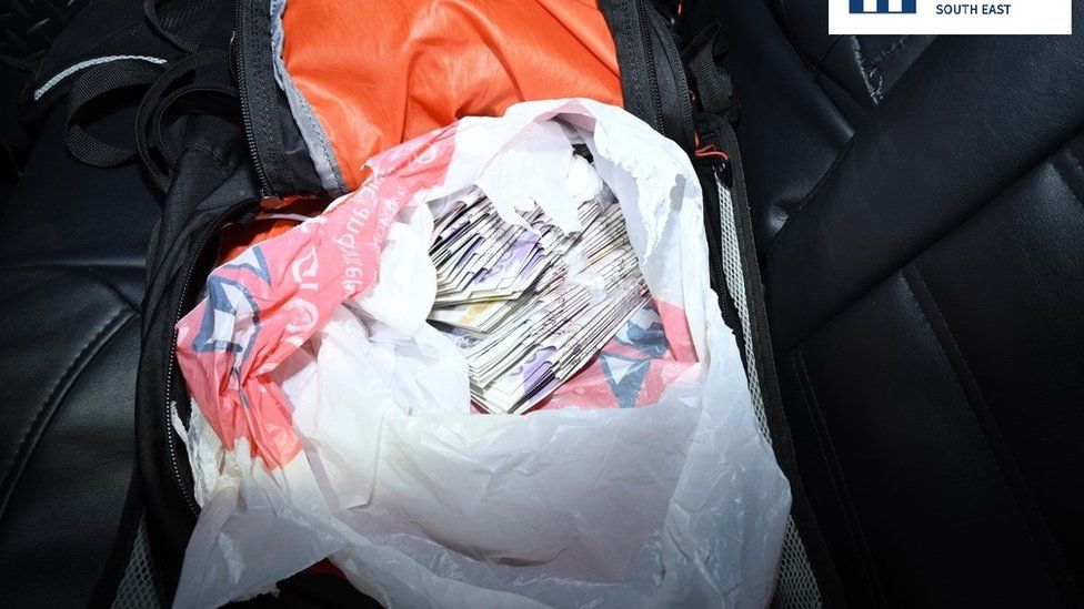Rucksack with money in backseat of car