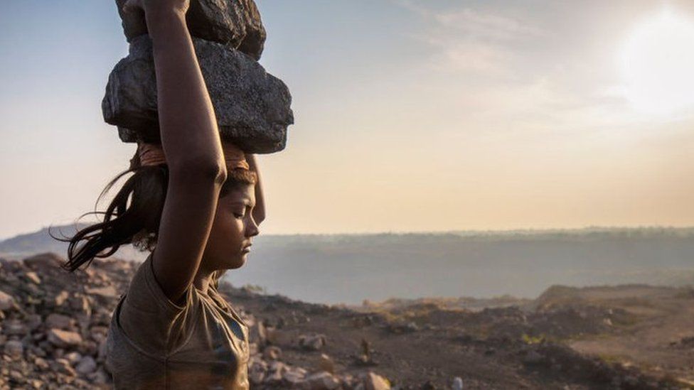 A woman carries coal on her head while working in the Jharia coal field in Jharkhand