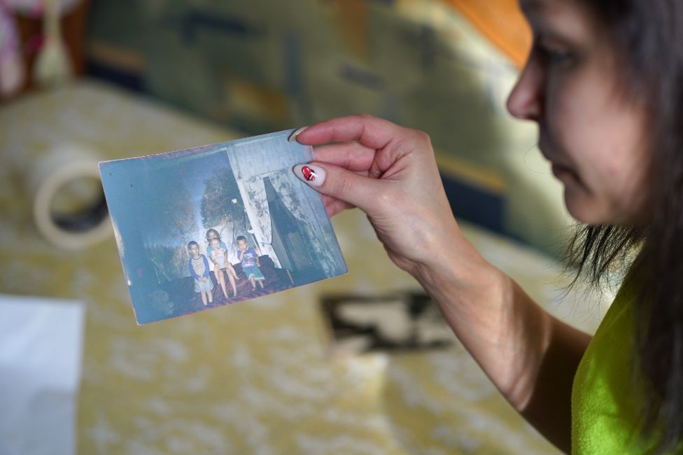 Hanna Kostseva with photograph of herself and her brothers as children