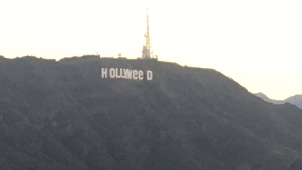 The iconic Hollywood sign, changed to read "Holyweed"