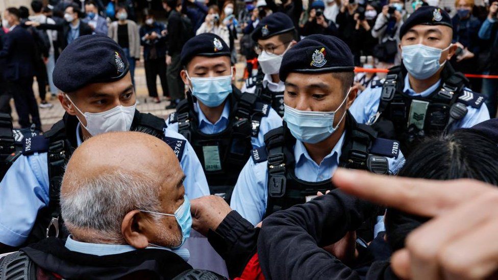 Supporters surrounded by Hong Kong police outside a court