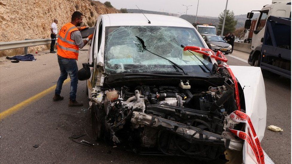Израильские военнослужащие и разбившийся автомобиль на месте атаки Ариэля (15.11.22)