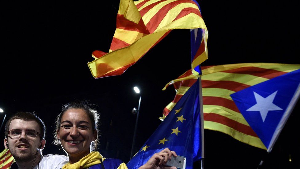 Catalan independence supporters celebrate as they wave European and Catalan flags 27 September 2015