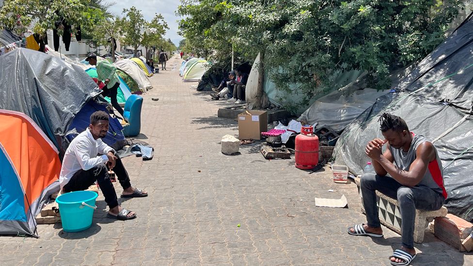 Africa migrants outside tents on a street in Tunisia