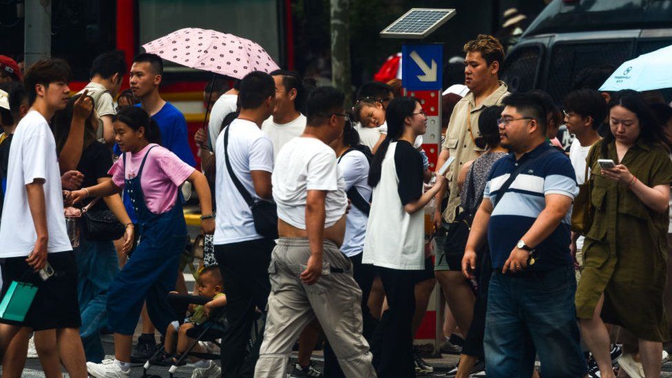 Tourists are seen crossing the street at Shanghai, China, on 6 July, 2023