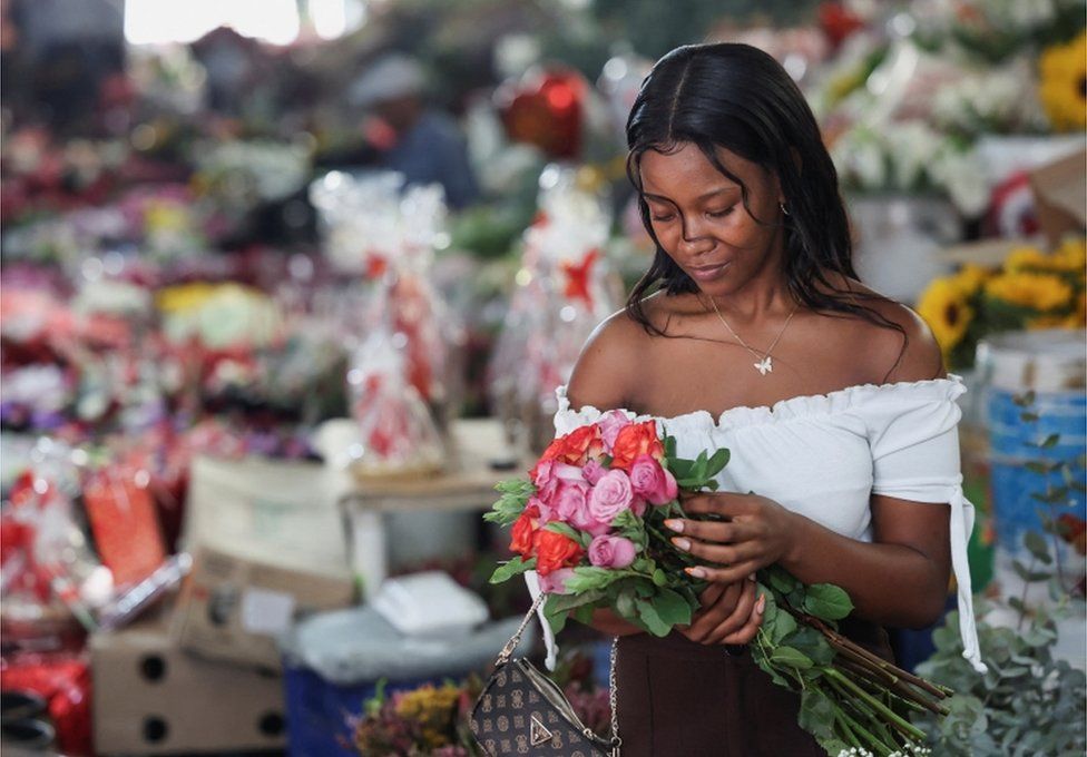 A woman holds roses at Adderley Street Flower Market.
