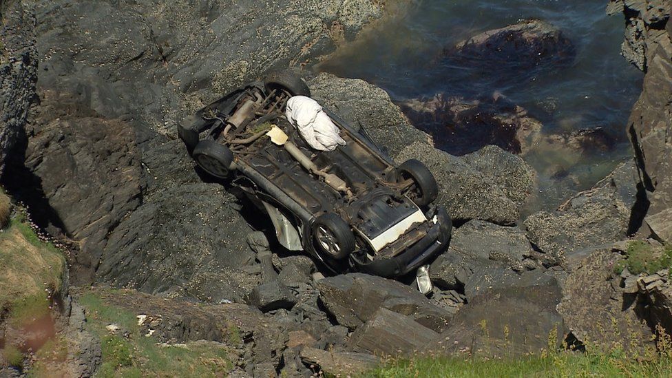 The car at the base of the cliff