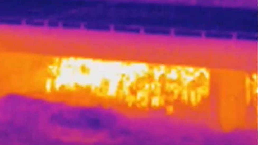Thermal camera shows people gathered under M6 bridge