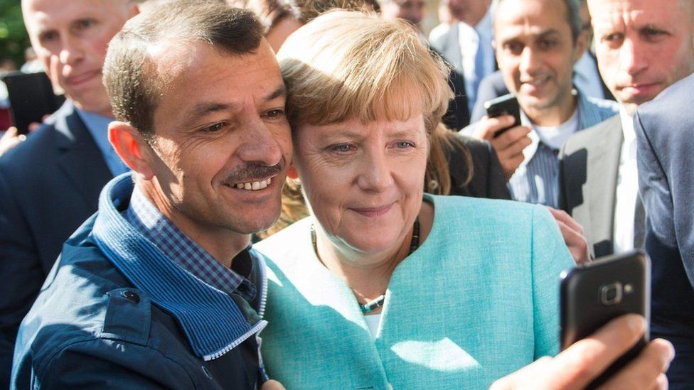 Angela Merkel poses for selfie with a man seeking asylum at a reception centre in Berlin (9 Sept)
