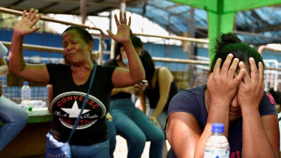 Родственница заключенной реагирует, пока другой человек пытается утешить ее, ожидая новостей о своих близких за пределами тюрьмы в Гуаякиле, Эквадор, 25 июля 2023 г.