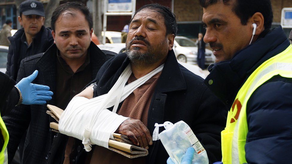 Afghan health workers carry a wounded man from a hospital after gunmen attacked a political gathering in Kabul, Afghanistan, 06 March 2020